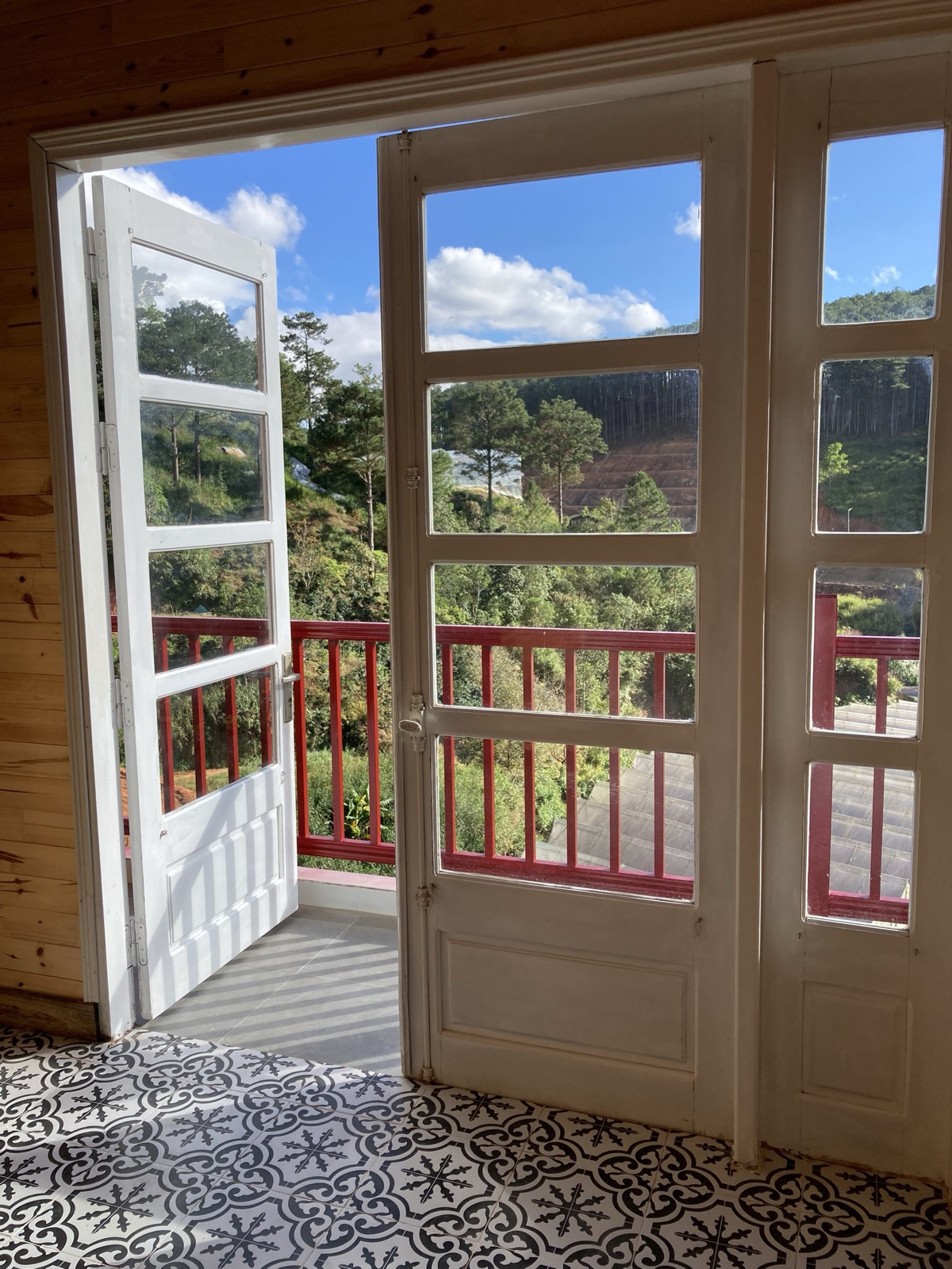 Cửa kính đôi dẫn ra ban công view đồi